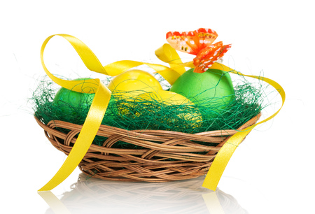 Colored Easter eggs in the basket and butterfly on a white background.の写真素材