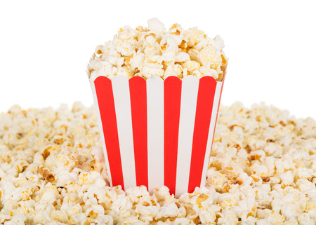 A large square box of popcorn and popcorn are many around, isolated on white background. Close-up.の写真素材