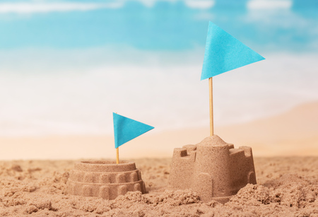 Sand Castle, the Colosseum and blue flags on the background of the coast.の写真素材