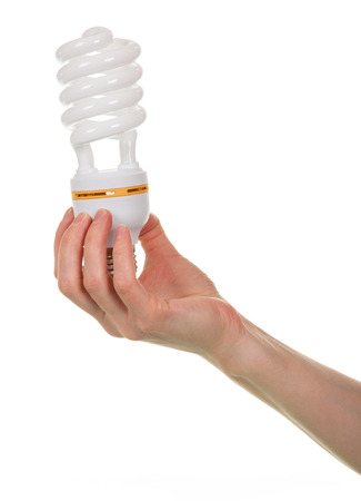 A female hand holds a fluorescent light bulb isolated on a white background. Close-up.の写真素材