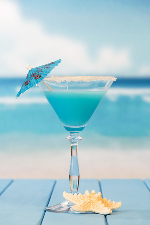 Cocktail with an umbrella and a starfish on the background of the sea.の写真素材
