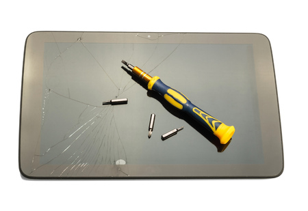 Broken digital tablet, and screwdriver bits isolated on a white background.の写真素材