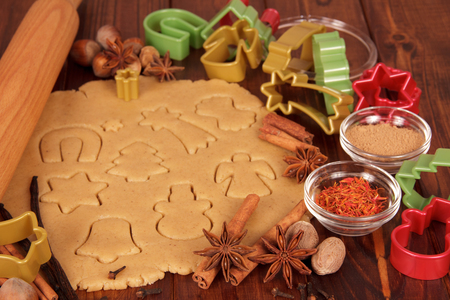 Molded cookies ready for baking, against the background of wooden tableの写真素材