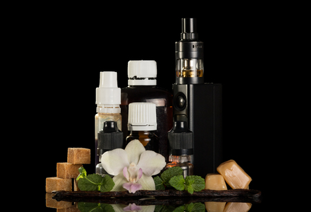Electronic cigarette for smoking, set of liquids and aromatic oils, sweets, isolated on black backgroundの写真素材