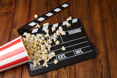 Black with white letters poppers, box of popcorn spilled on a background of dark wood.の写真素材