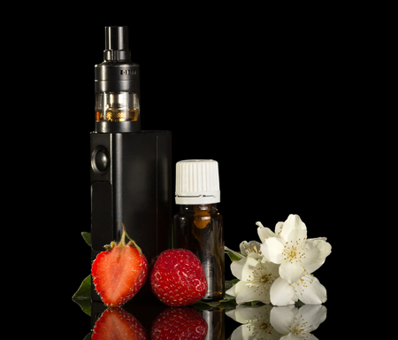 Electronic cigarette and liquid for smoking, strawberries isolated on black backgroundの写真素材