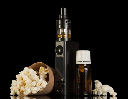 Electronic cigarette liquid for smoking, scattered popcorn isolated on black backgroundの写真素材