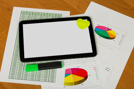 Tablet and heart, marker, sheets of paper account and charts on the desktop background.の写真素材