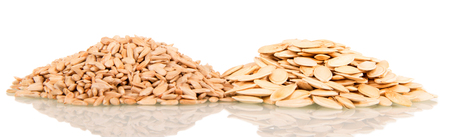 Heap of unpeeled pumpkin seeds and peeled sunflower seeds isolated on white background.の写真素材