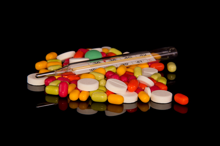 Pharmaceutical medicines and thermometer isolated on black backgroundの写真素材