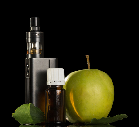 Device for inhaling aromatic liquids and an apple isolated on black backgroundの写真素材