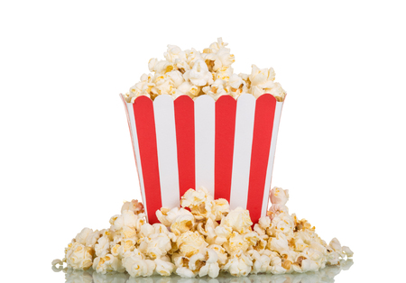 Square box filled with popcorn, part scattered, isolated on white backgroundの写真素材