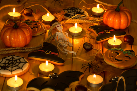 Composition for Halloween in the light of candles. Gingerbread, spiders, skeleton, pumpkinsの写真素材
