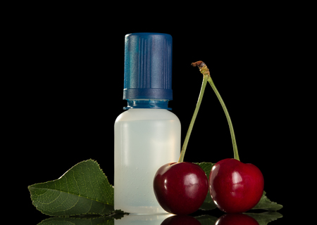 Liquid for smoking with cherry flavor, isolated on black backgroundの写真素材