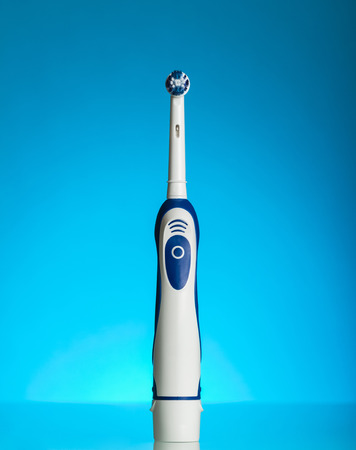 An electric device for oral care is on blue backgroundの写真素材