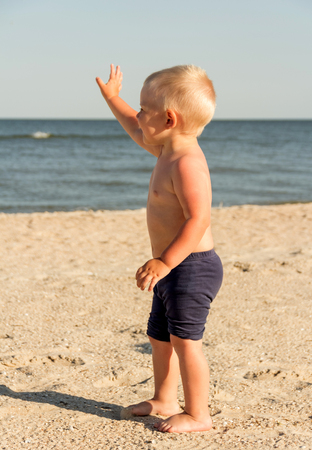 Summer. Happy child on the beach wavingの写真素材