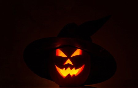 Scary Halloween pumpkins isolated on a black background. Scary glowing faces trick or treatの写真素材