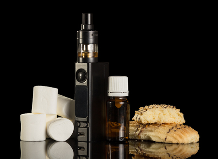 Electronic cigarette and liquid with the taste of the biscuit and marshmallow isolated on black backgroundの写真素材