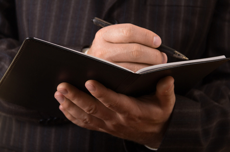 Workflow, in the hands of a businessman diary and pen. Close-upの写真素材