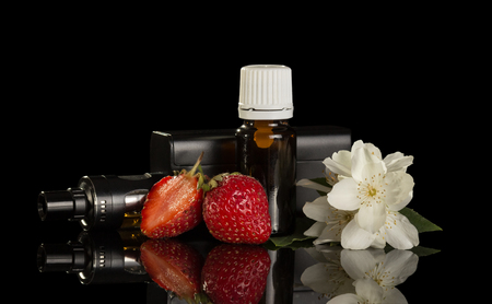 Liquid with fruity scent for smoking an electronic cigarette isolated on black backgroundの写真素材