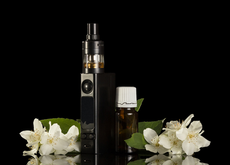Electronic cigarette and liquid with floral scent isolated on black backgroundの写真素材