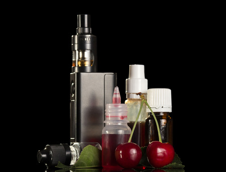 Electronic cigarette and set of aromatic liquids for smoking isolated on black backgroundの写真素材
