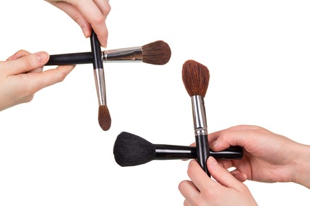 Set of cosmetic brushes of various size and density in hands isolated on white backgroundの写真素材