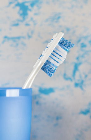 Toothbrush in glass close-up, on blue backgroundの写真素材