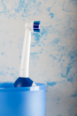 Close-up, an electric toothbrush stands in a glassの写真素材