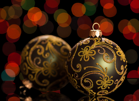 Two beautiful Christmas balls, decorated with patterns, are located on dark shimmering backgroundの写真素材
