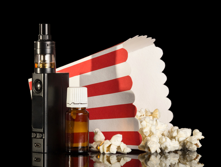 Electronic cigarette and liquid with the taste of popcorn isolated on black backgroundの写真素材