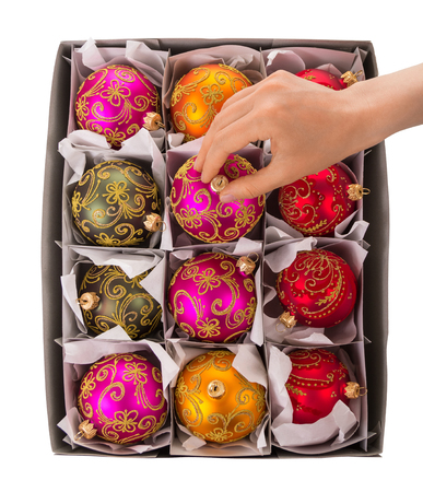 A woman's hand takes bright, colorful New Year's toys out of the boxの写真素材