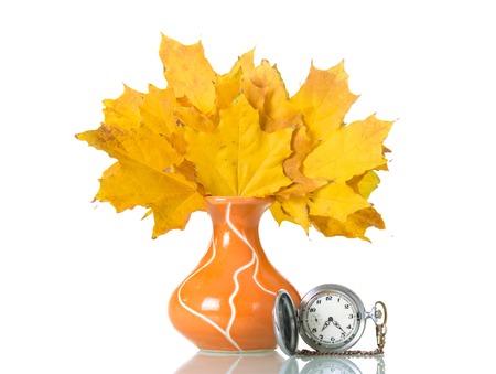 Maple leaves in orange vase and clock isolated on white backgroundの写真素材