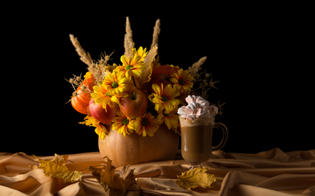 Bouquet of autumn flowers in pumpkin and latte on draped gold fabricの写真素材