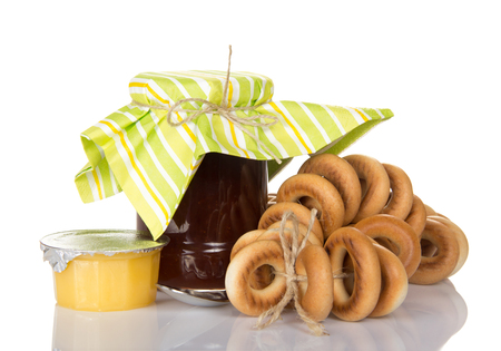 Jar fragrant jam a bunch of bagels and honey isolated on white backgroundの写真素材