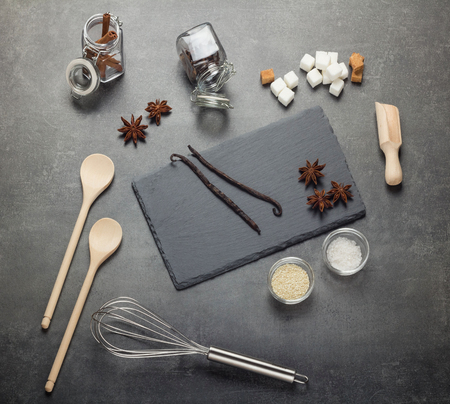 Set of aromatic spices, sesame seeds, salt, sugar and kitchenware, on gray backgroundの写真素材