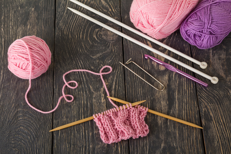Skeins of thread, needles, hook, linked sample, on wooden surfaceの写真素材