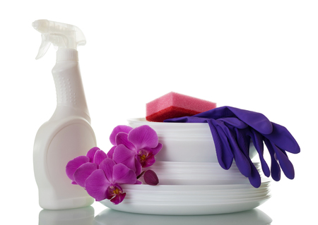 Pile of clean dishes, detergent, blue gloves and Orchid flowers, isolated on whiteの写真素材