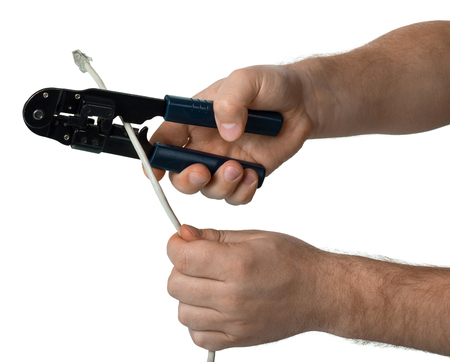 Mens hands with cutter cut the cable isolated on whiteの写真素材