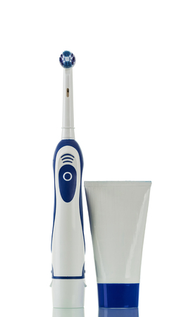 Electric toothbrush and tube of toothpaste isolated on whiteの写真素材