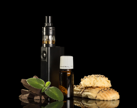 Electronic cigarette, flavored liquid, chocolate and biscuits, mint leaf, isolated on black