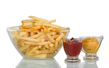 Fried potatoes in large glass bowl, ketchup and mustard isolated on whiteの写真素材