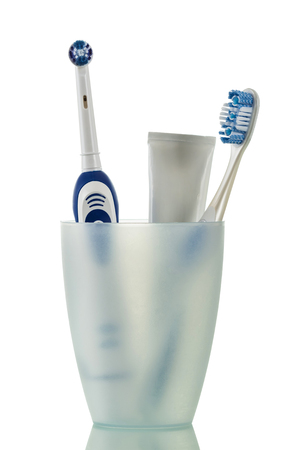 Electric toothbrush, manual toothbrush and toothpaste in Cup isolated on whiteの写真素材