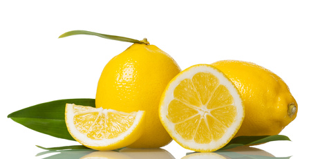Two whole lemons with leaves and pieces isolated on whiteの写真素材