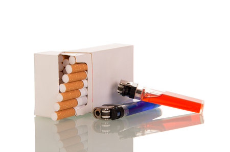 Pack of cigarettes, next to two lighters, isolated on whiteの写真素材