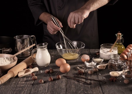Ingredients for baking , Baker prepares dough isolated on blackの写真素材