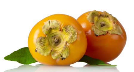 Two ripe tropical persimmon fruits, with leaves isolated on whiteの写真素材
