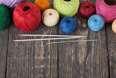 Multicolored balls of cotton threads for needlework, on wooden surfaceの写真素材