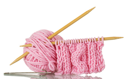 Pink fluffy ball of yarn, wooden knitting needles and pin for handicraft isolated on whiteの写真素材