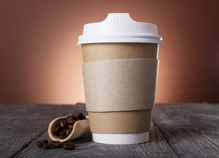 Special container with lid for coffee, near scoop with coffee beans on tableの写真素材